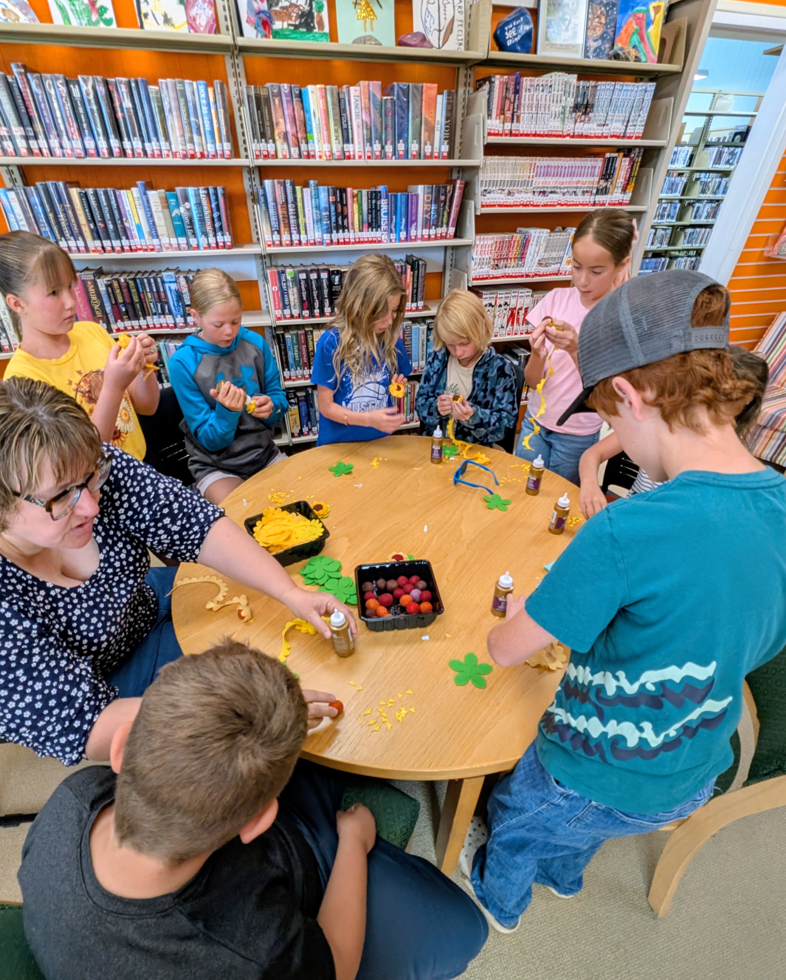 Sheep arts IYRP exhibit at Harney County Library. Crafting at a table. 